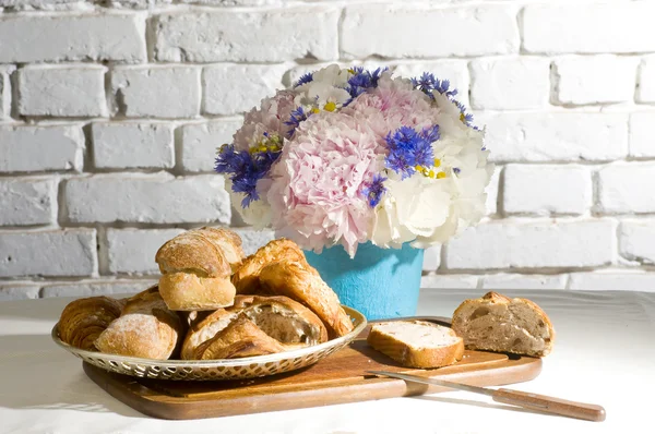 Peony and cornflower bouquet with some bread