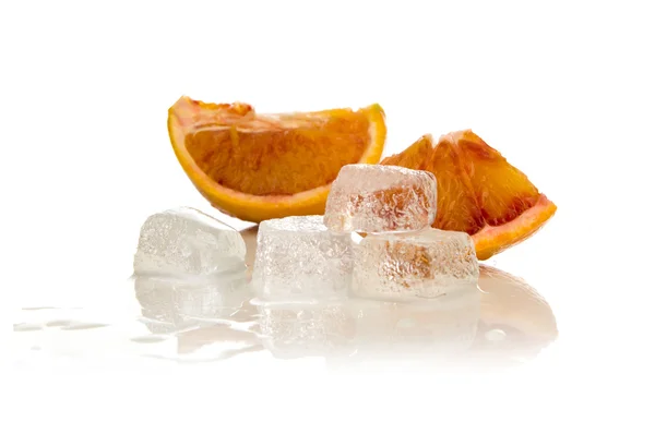 Su ve portakal dilimleri içinde erimiş buz küpleri — Stok fotoğraf