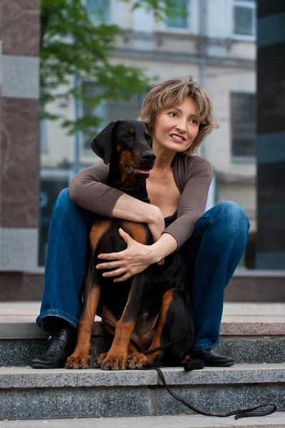Η νεαρή γυναίκα με έναs σκύλοs σε μια σκάλα — Φωτογραφία Αρχείου
