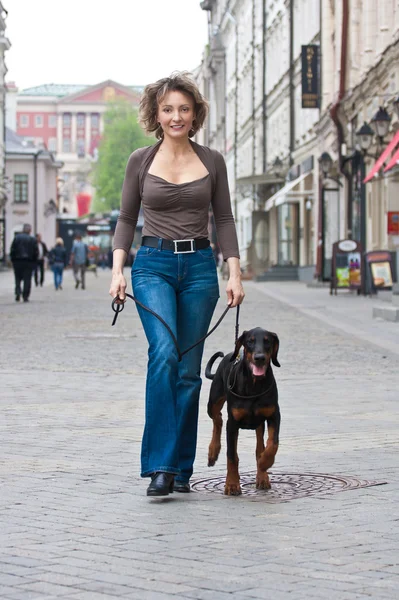 Mladá žena se psem na žebříku — Stock fotografie