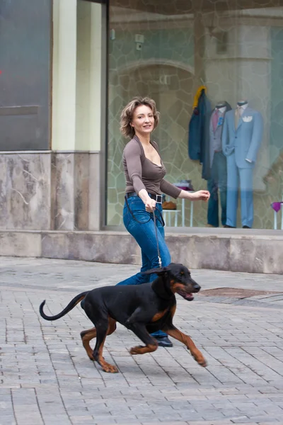 Den unga kvinnan med en hund på en stege — Stockfoto