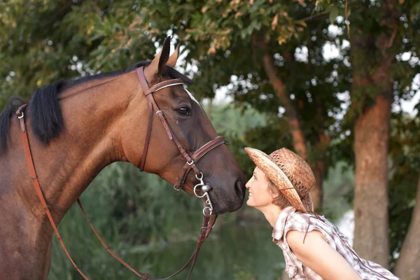 Mujer con sombrero y caballo cara a cara . — Foto de Stock