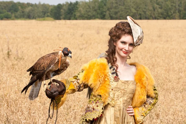Žena v krásné staré šaty styl s falcon má odpočinek — Stock fotografie