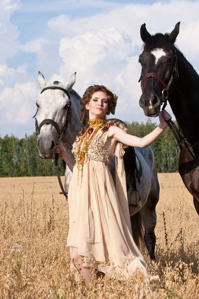 女性は 2 頭の馬を保持します。 — ストック写真