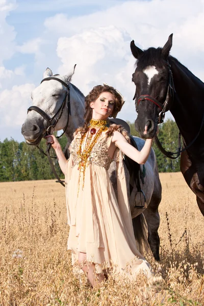 Die Frau hält zwei Pferde — Stockfoto