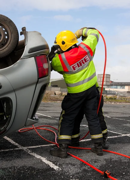 Bombero con cuña de energía en resque accidente de coche —  Fotos de Stock