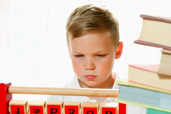Boy put together letters on the wooden cubes — Stock Photo, Image