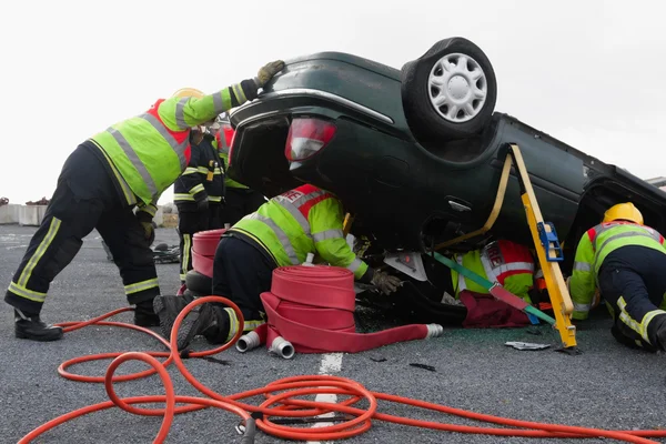 Strażacy z wyposażeniem w wypadku samochodowym — Zdjęcie stockowe