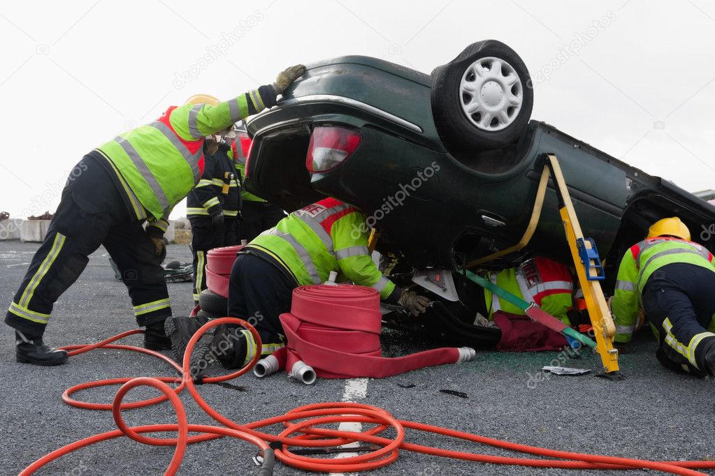 Firemen with equipment at car crash