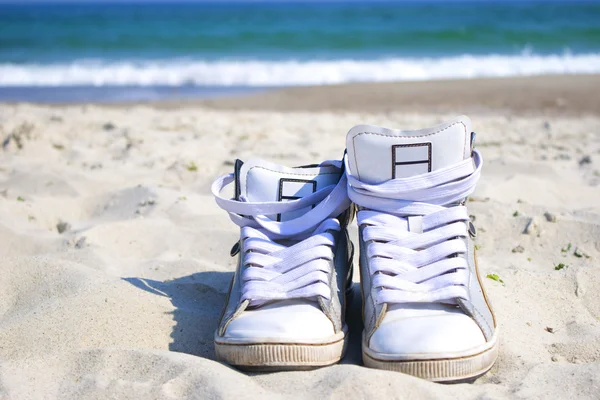 Sneakers op het strand — Stockfoto