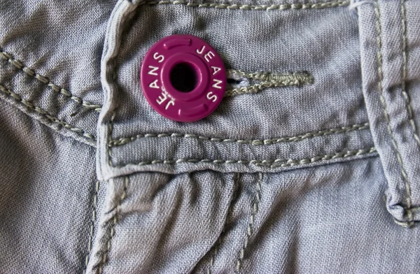 Jeans med rosa knappen — Stockfoto