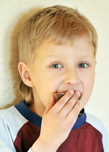 Niño comiendo huevo de chocolate — Foto de Stock