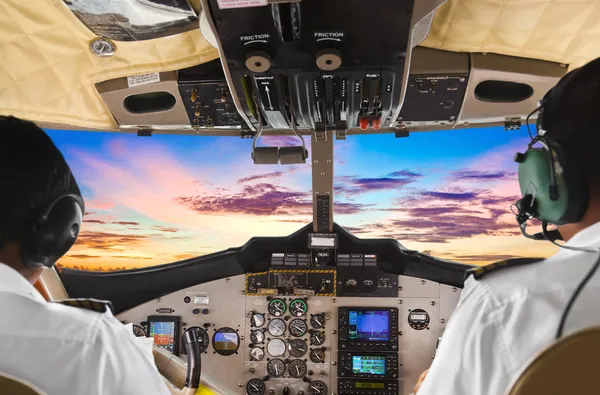 Piloten im Cockpit des Flugzeugs und Sonnenuntergang Stockbild