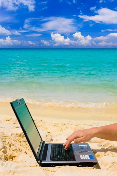 Computador e mão na praia — Fotografia de Stock