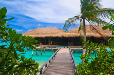 Water bungalows on a tropical island clipart