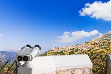 Binoculars and Arachova on mountain Parnassos, Greece clipart