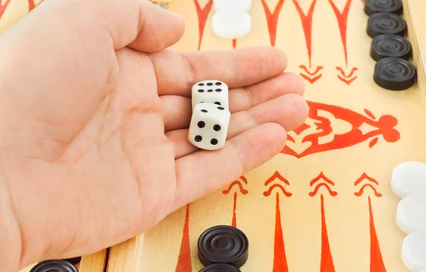 Hand met dobbelstenen en backgammon — Stockfoto