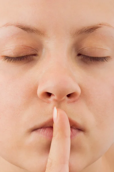 Woman holding finger to lips — Stock Photo, Image