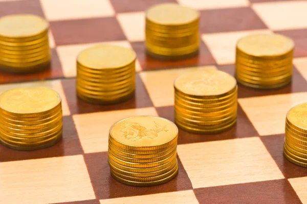 Dinero en tablero de ajedrez Imagen de archivo