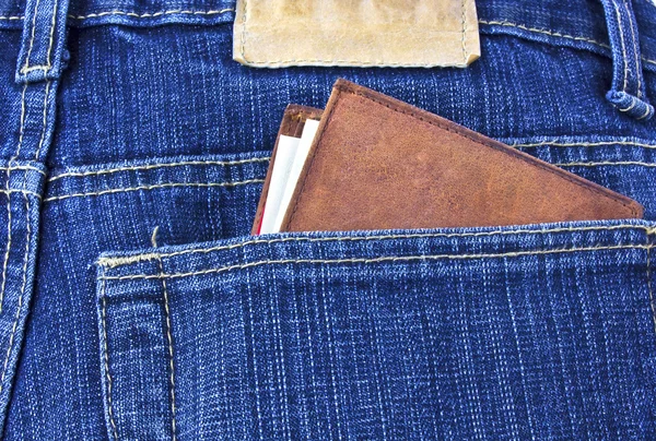Lederen portefeuille met geld in spijkerbroek — Stockfoto