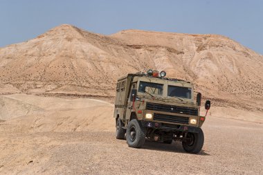 Israeli army Humvee on patrol in the Judean desert clipart