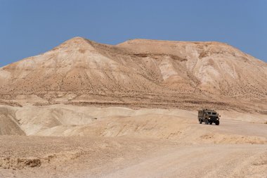 Israeli army Humvee on patrol in the Judean desert clipart