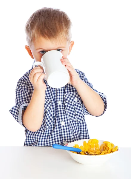 Мальчик ест хлопья из миски — стоковое фото