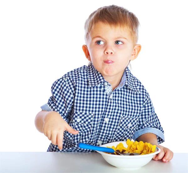 Ein Junge isst Getreide aus einer Schüssel — Stockfoto
