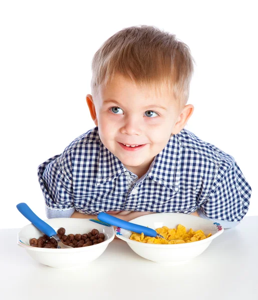 Un garçon mange des céréales dans un bol — Photo