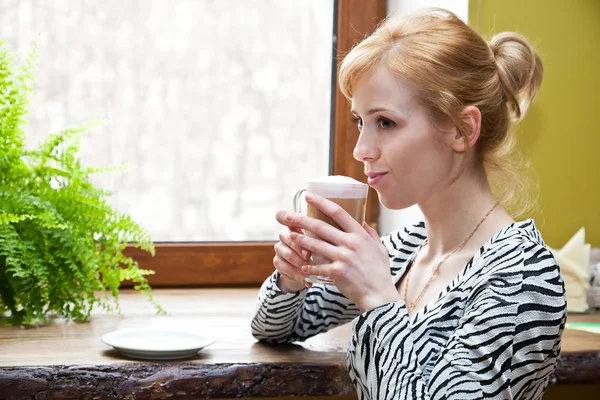 Een mooie vrouw drinkt koffie — Stockfoto