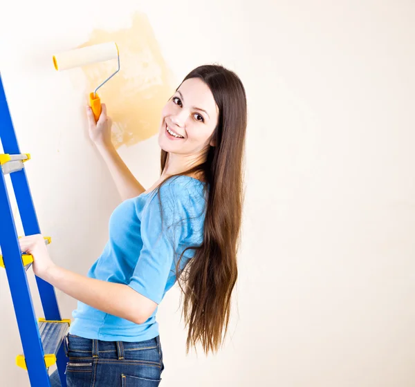 A woman is painting walls — Stock Photo, Image