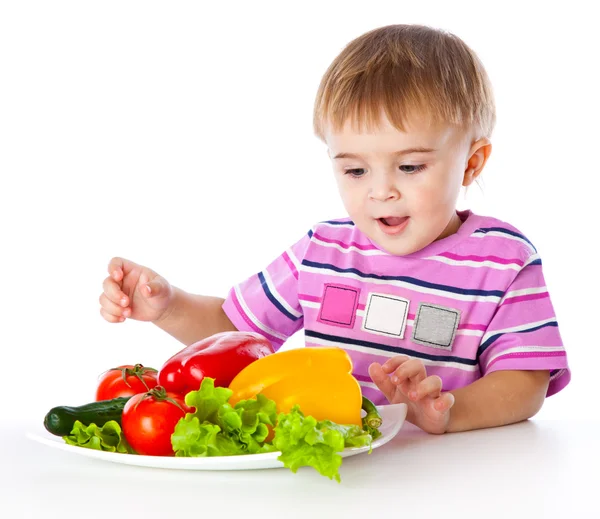Мальчик и тарелка овощей — стоковое фото