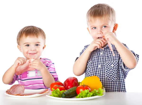 Boys and plates of vegetables and meat — Stock Photo, Image