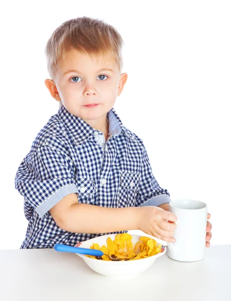 Un chico come cereales de un tazón. —  Fotos de Stock