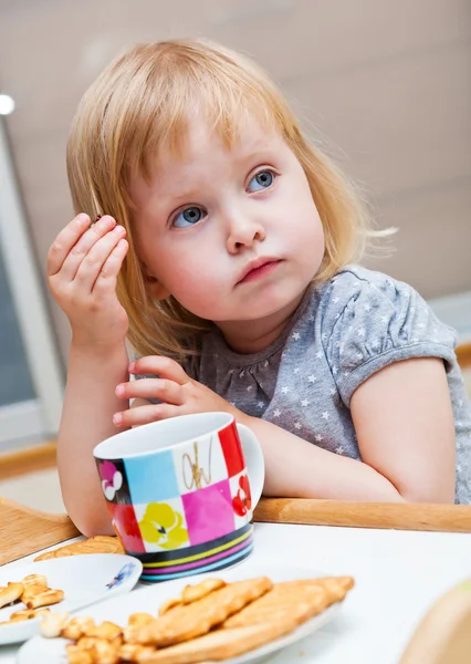 Malá holčička je jíst cukroví — Stock fotografie