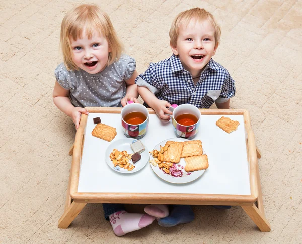 Funny children are eating dessert — Stock Photo, Image