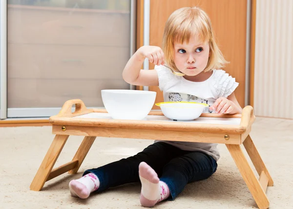 Uma menina pequena está comendo — Fotografia de Stock