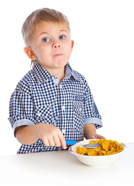 Мальчик ест хлопья из миски — стоковое фото