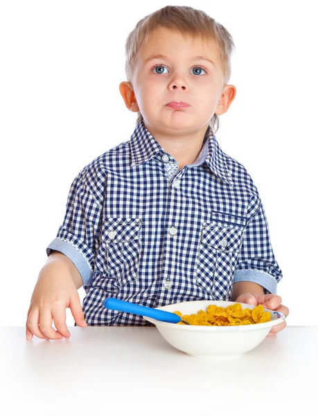 En pojke äter spannmål från en skål — Stockfoto