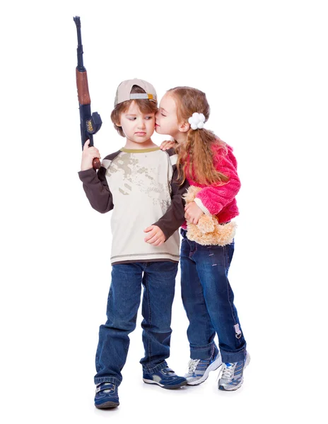 A girl is kissing a boy with the gun — Stock Photo, Image