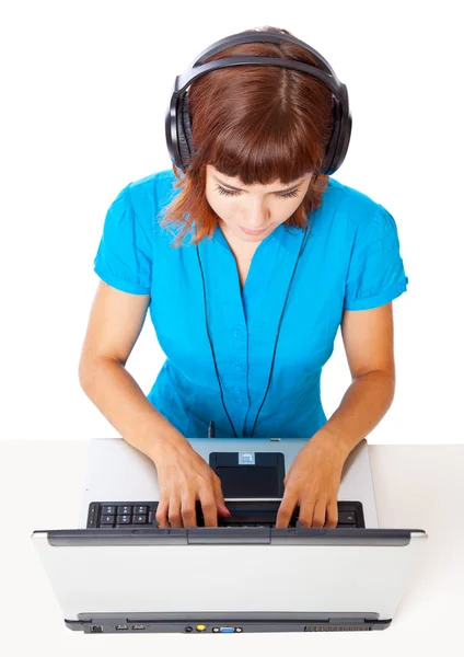 Roodharige tiener-meisje luisteren naar muziek in hoofdtelefoon met laptop — Stockfoto