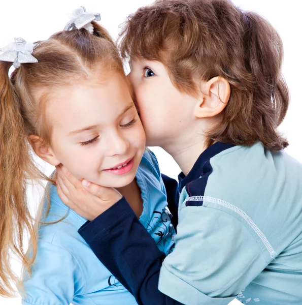 Мальчик целует маленькую девочку — стоковое фото