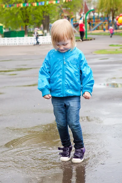 A girl is jumping in the puddle — Stock Photo, Image