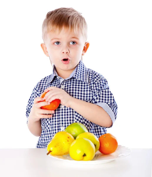 Мальчик и тарелка с фруктами — стоковое фото