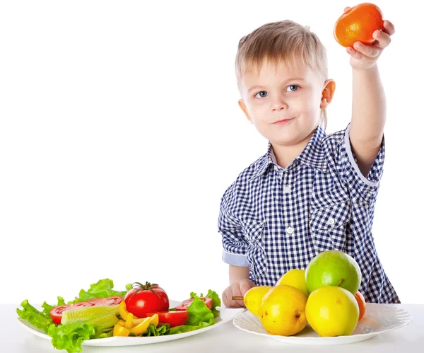 Хлопчик і тарілка овочів і фруктів — стокове фото