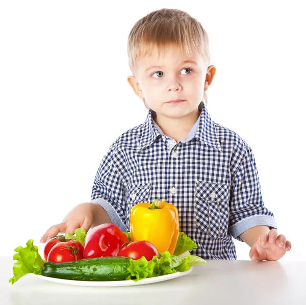 Мальчик и тарелка овощей — стоковое фото