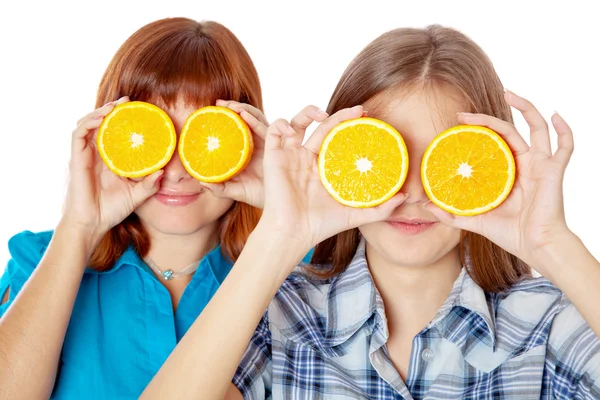 Две девушки смотрят сквозь апельсины — стоковое фото