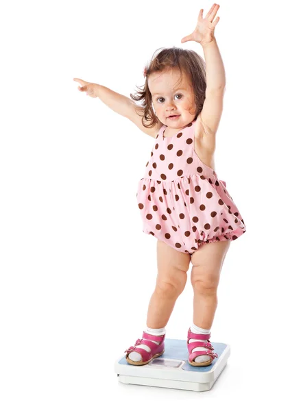 Маленькая девочка стоит на весах — стоковое фото