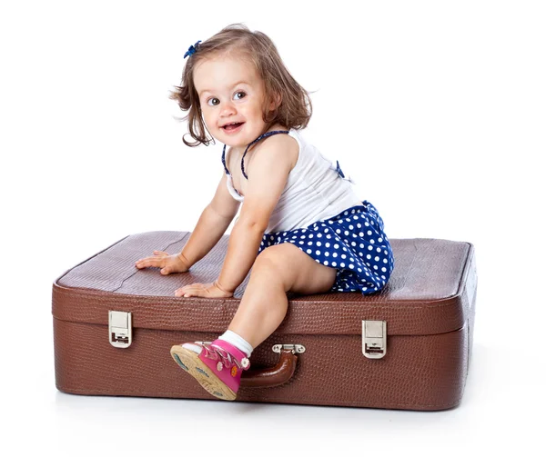 Ein kleines Mädchen auf dem Koffer — Stockfoto