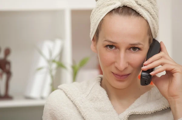 Mulher em roupão de banho com telefone — Fotografia de Stock